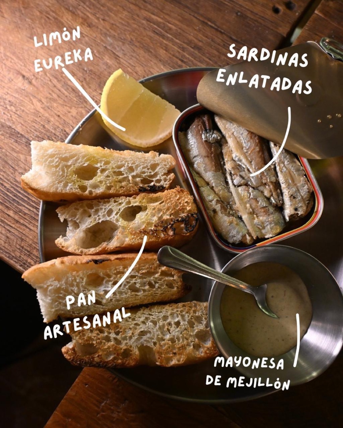 Lata de sardinas abierta con pan artesanal, limón eureka y mayonesa de mejillón